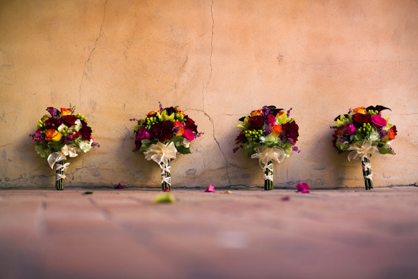 Multicolored bouquets with white ribbon - wedding photo by Melissa Jill Photography